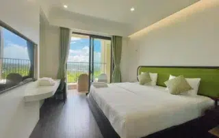 Phòng ngủ với giường đôi và cửa mở ra ban công trong ảnh giới thiệu H3 Hillside Residence
