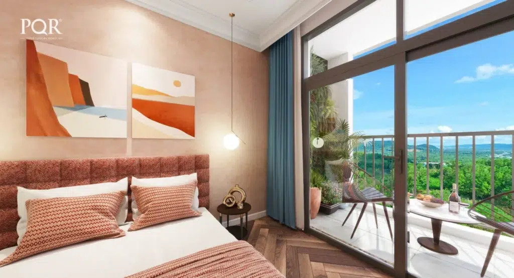 Phối cảnh Studio The Sky với giường màu cam cạnh cửa kính ban công và rèm xanh